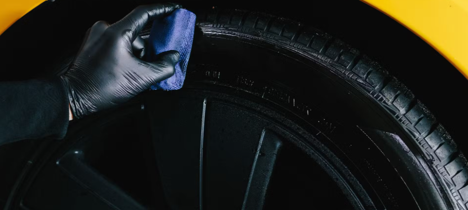 Reifenpflege: Auftragen von Pflegemittel an der Reifenflanke mit Mikrofasertuch